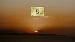 American Express Gold Card vor einem Sonnenuntergang über dem Meer