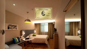 American Express Gold Card aus Metall über einem Hotelzimmer mit warmem Abendlicht, Beitragsbild zum Willkommensbonus der Amex Gold