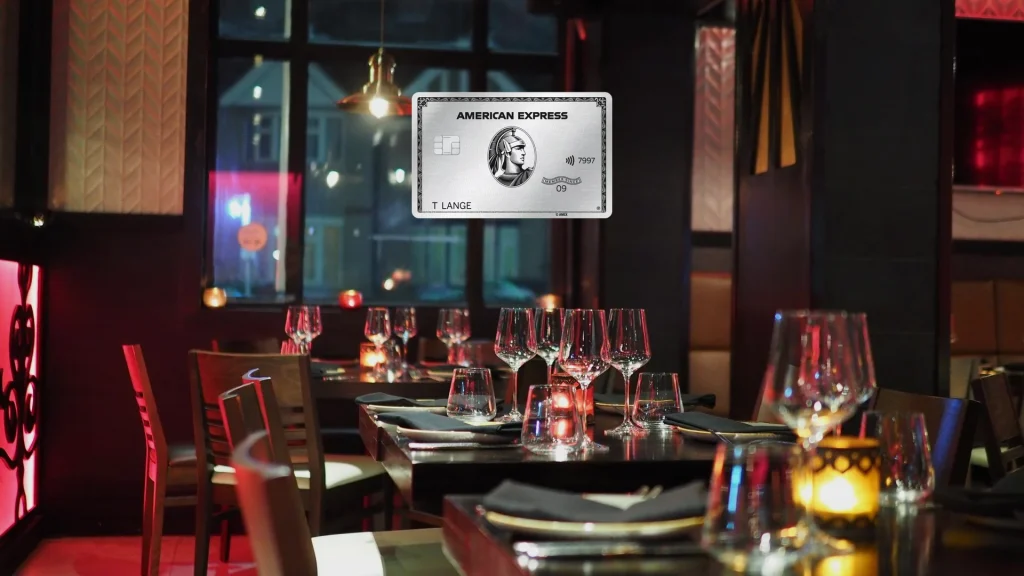 American Express Platinum Card vor einem gedeckten Restauranttisch am Abend