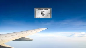 American Express Platinum Card vor einem Flugzeugflügel über einer Wolkendecke