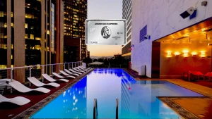 American Express Platinum Card vor einem Rooftop-Pool mit Hochhauskulisse am Abend