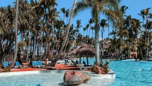 Pool einer Ferienanlage mit Palmen, Sinnbild fuer eine Reise, die mit umgewandelten PAYBACK Punkten bezahlt wurde